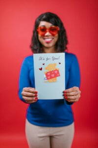 Woman in Blue Long Sleeve Shirt Holding a Valentines Card