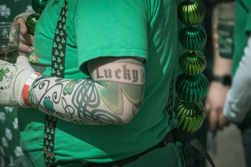 a person wearing a green shirt with a tattoo on it