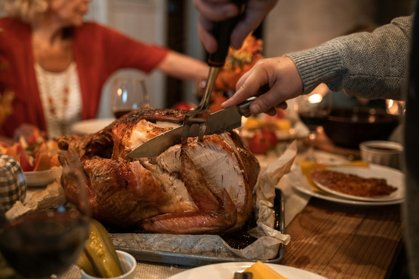 Celebrate Thanksgiving with a roast turkey feast and family around a cozy dinner table indoors.