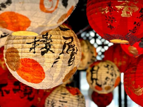 a bunch of paper lanterns hanging from a ceiling